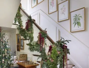 Foyer with Christmas tree, staircase decorated with garland, and bronze dog statue