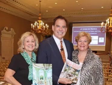 Three people holding books, one titled "At Home in France" and another "Atlanta Homes"