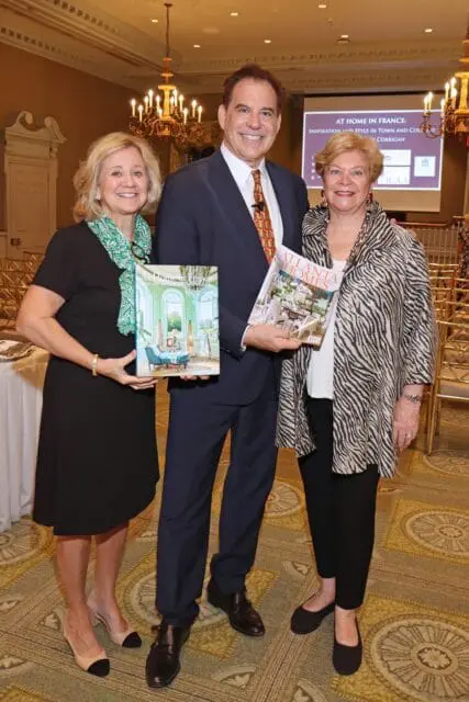 Three people holding books, one titled "At Home in France" and another "Atlanta Homes"