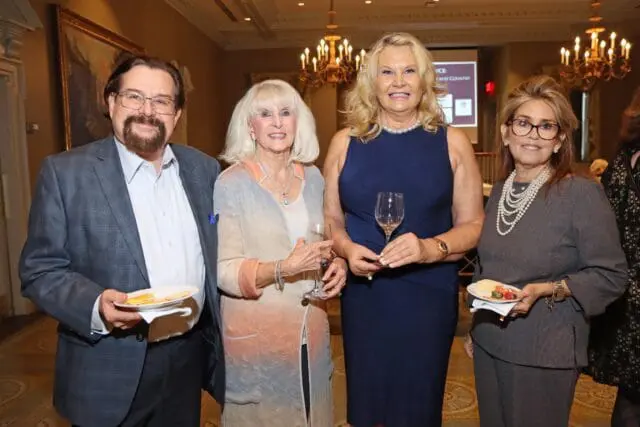 Four people posing for a photo at an event.
