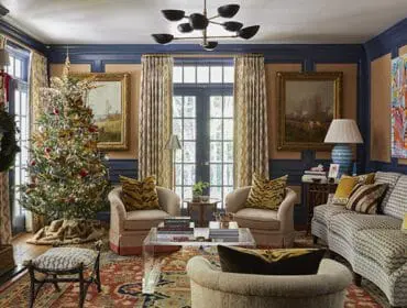 Living room with Christmas tree, fireplace, patterned sofa, and tiger print pillows.