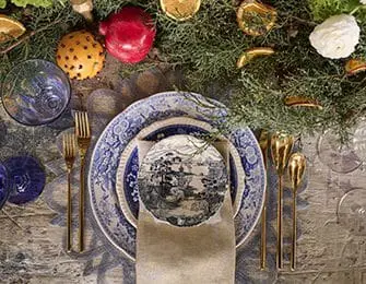 Blue and white patterned plates with gold cutlery on a rustic wooden table