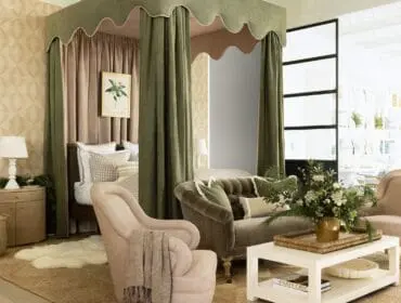Bedroom with green canopy bed, tufted sofa, armchair, and white coffee table.