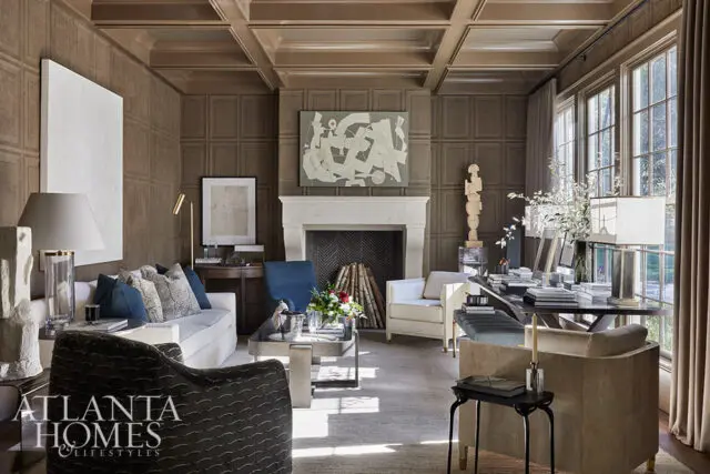 Living room with coffered ceiling, paneled walls, fireplace, and seating areas.