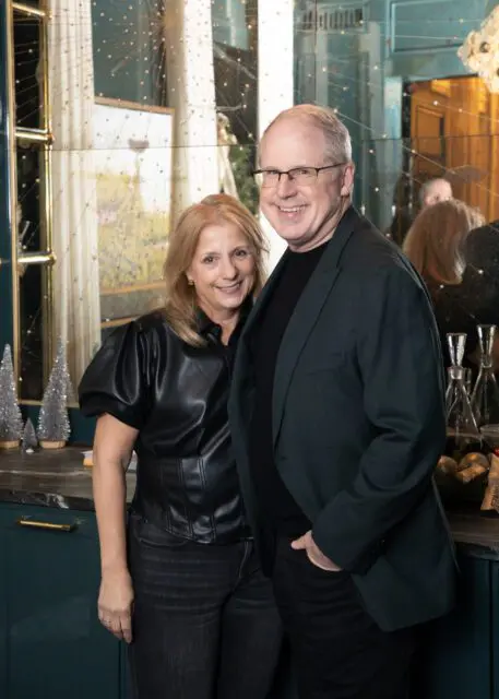 Man in glasses and dark jacket with woman in black leather top and jeans