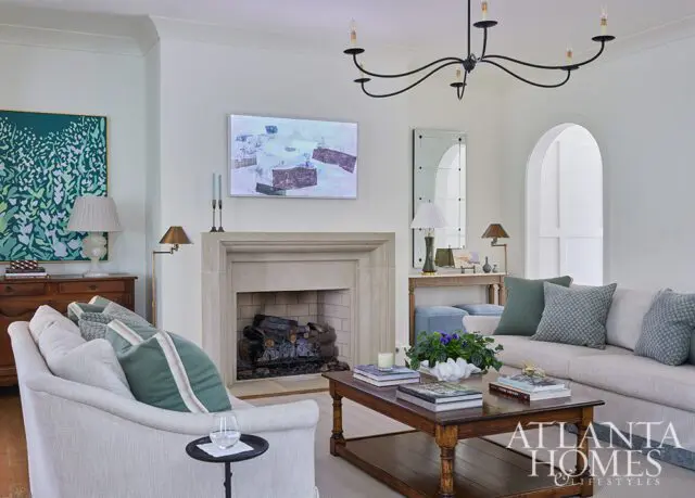 Living room with fireplace, sectional sofa, coffee table, and abstract art.