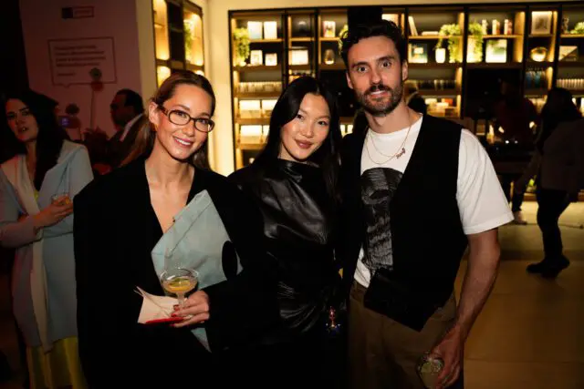 Three people posing for a photo at an event.