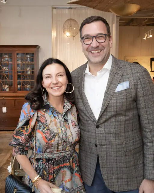 Man in plaid jacket and woman in patterned dress smiling