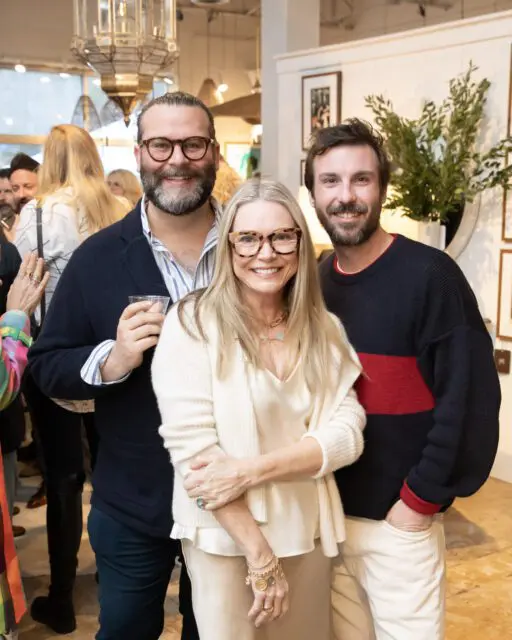 Man with beard and glasses, woman with glasses, and man smiling at event