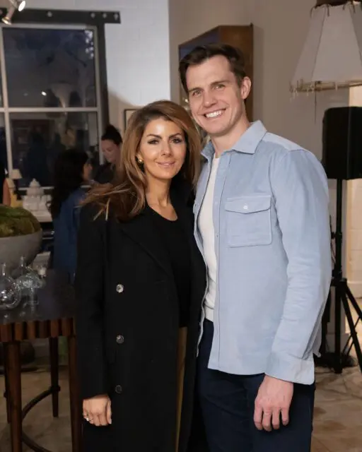 Woman in black coat and man in light blue shirt smiling