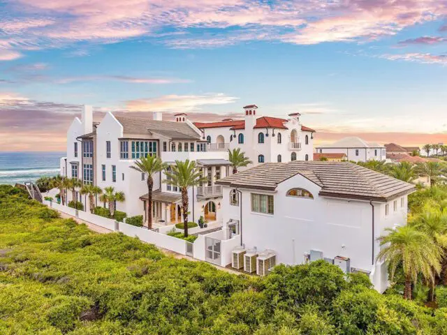 White Mediterranean-style mansion with red tile roofs overlooking the ocean.