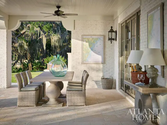 Covered patio with dining table, wicker chairs, and large glass vases.