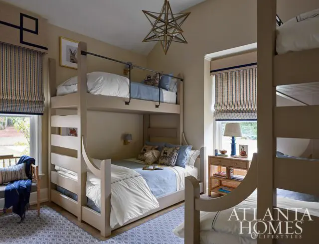 Tan bedroom with bunk beds, blue and white striped curtains, and starburst chandelier.