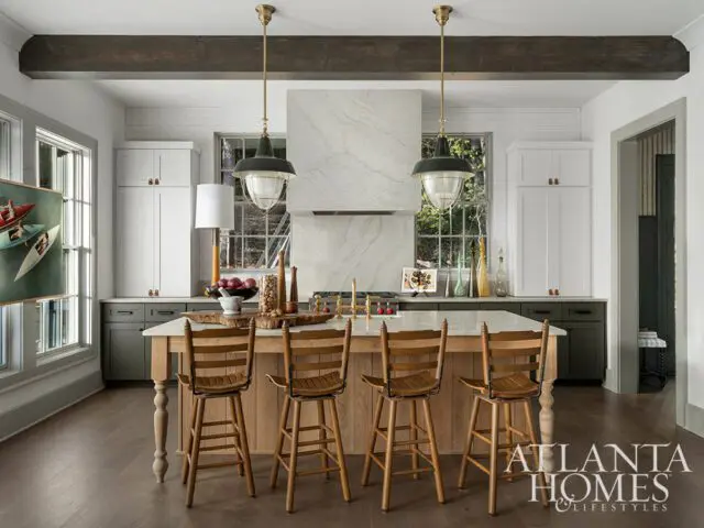 Kitchen with marble range hood, wood island, and bar stools. Atlanta Homes & Lifestyles logo.
