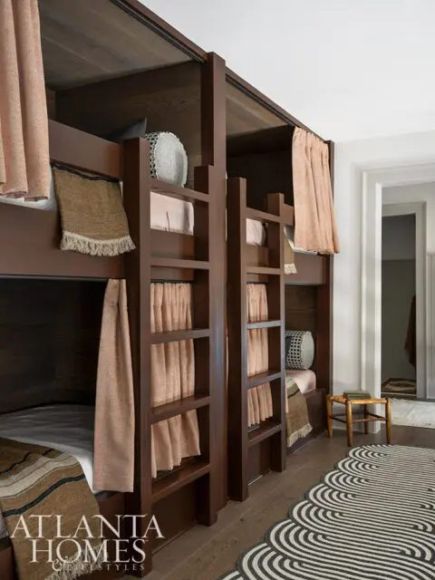 Dark wood bunk beds with peach curtains and woven throws.