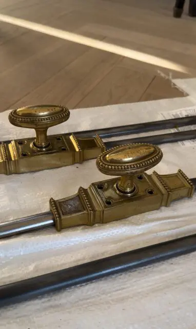 Brass window latches with oval knobs and decorative trim