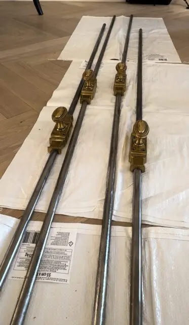 Four metal rods with ornate brass handles and bases