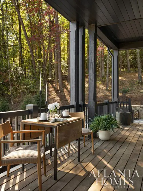 Wooden porch with dining set and forest view.