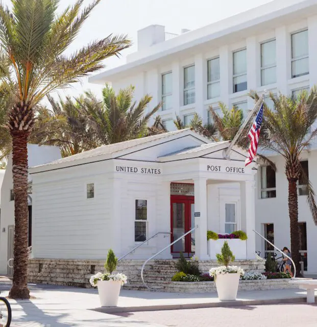 White United States Post Office with red doors and palm trees