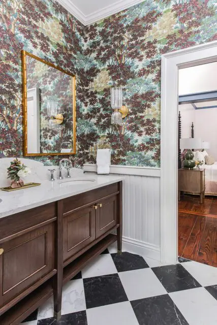 Bathroom with tree-patterned wallpaper, dark wood vanity, marble countertop, and black and white