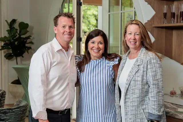 Man in pink shirt, woman in blue striped dress, woman in tweed jacket