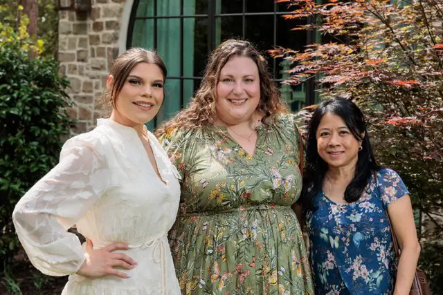 Three women posing for a photo outdoors.