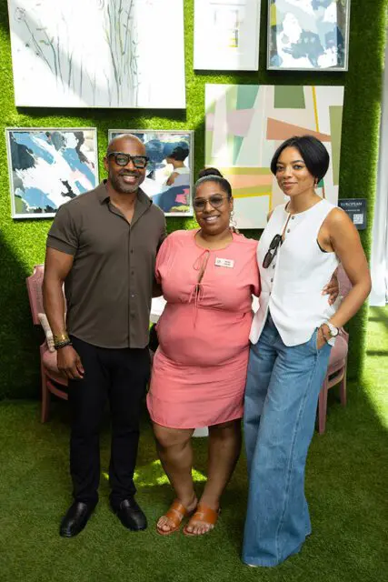 Man in olive shirt, woman in pink dress, woman in white vest and jeans