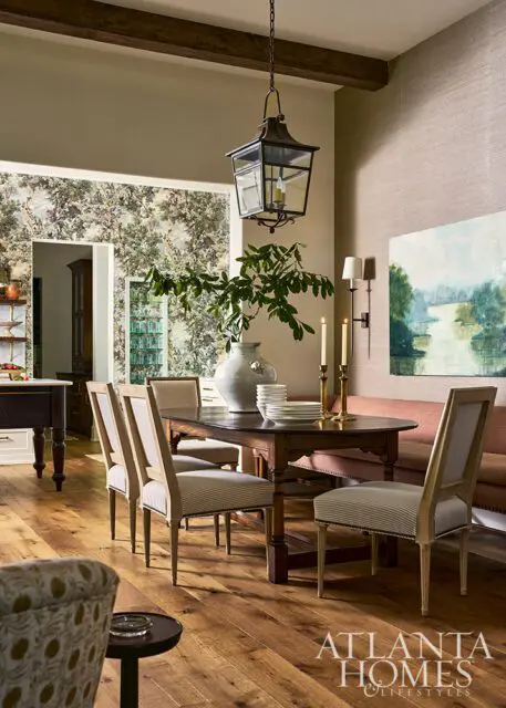 Dining room with dark wood table, striped chairs, floral wallpaper, and lantern pendant light.