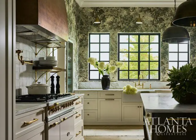Kitchen with floral wallpaper, copper range hood, and cream cabinetry.