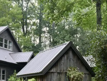 Rustic wooden shed surrounded by lush garden with hydrangeas and purple flowers