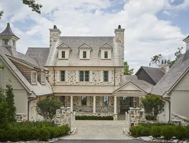 Stone and shingle house with dormer windows and cupolas