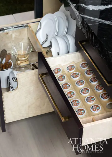 Drawer with coffee pods and plates, Atlanta Homes & Lifestyles logo
