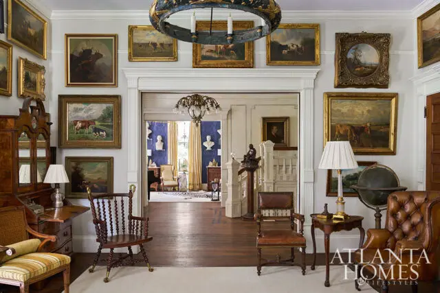 Living room with antique furniture, cow paintings, and ornate chandelier.