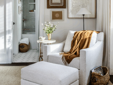 White armchair with brown throw and ottoman in bathroom.
