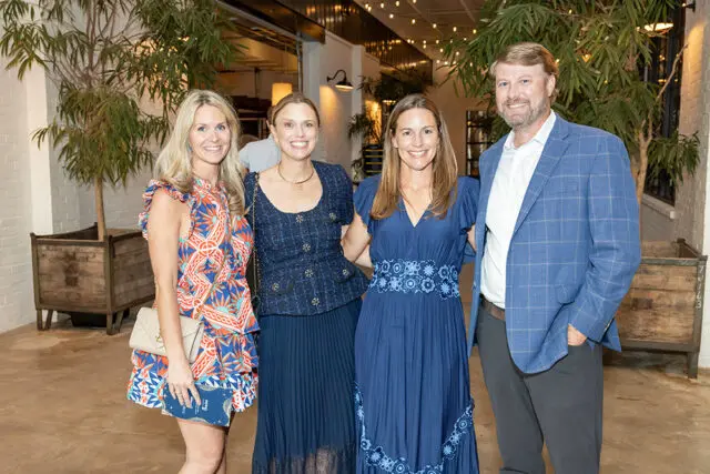 Four people posing for a photo at an event.
