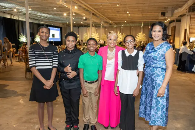 Group of six people, including children and adults, posing for a photo indoors.