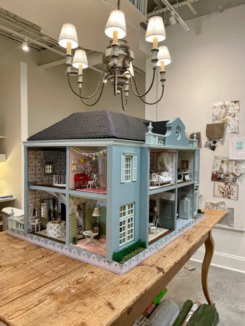 Dollhouse with detailed interior rooms including a piano and bedroom.
