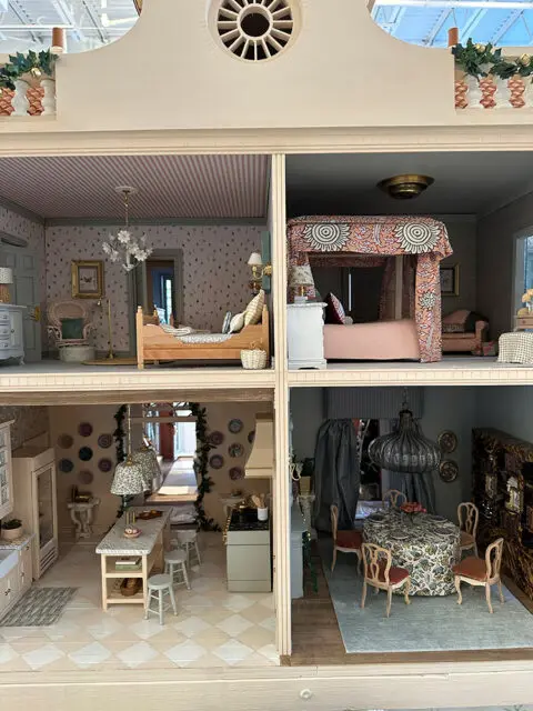 Dollhouse interior with four rooms: two bedrooms, a kitchen, and a dining room.