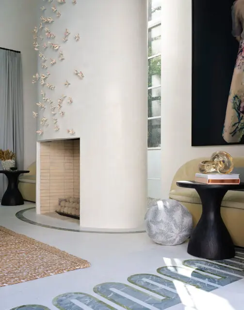 Living room with curved fireplace, abstract wall art, and marble floor inlay