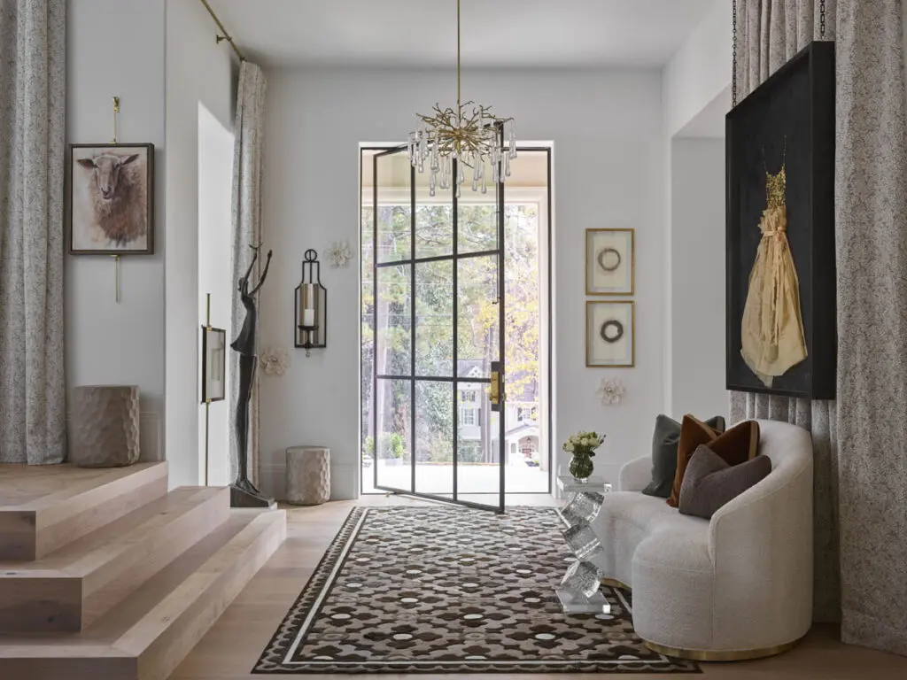 Entryway with wood stairs, abstract art, sculpture, and curved sofa