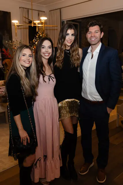 Four people posing for a photo indoors.