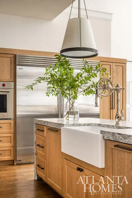 Wood kitchen with granite countertops, farmhouse sink, and stainless steel appliances.