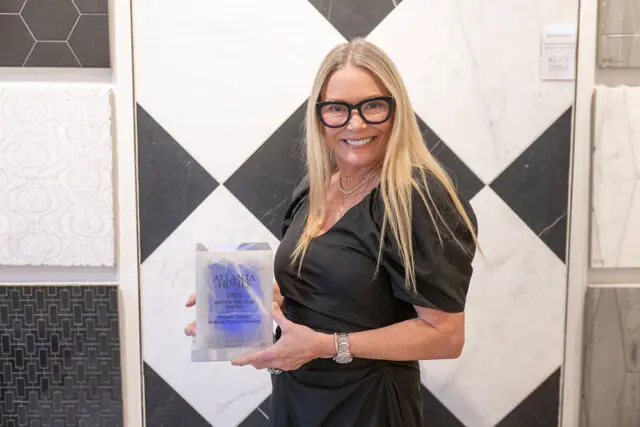 Woman in black dress holding Atlanta Homes 2025 Bath of the Year award