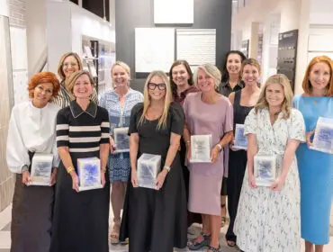 Group of women holding awards in a showroom with tile displays