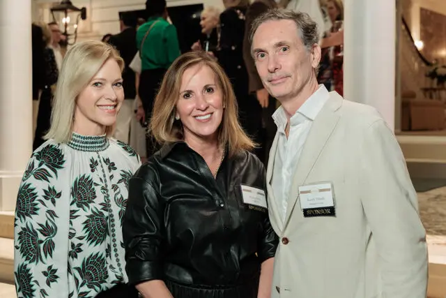 Three people posing for a photo, two women and one man. The woman on the left wears a white shirt