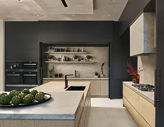 Modern kitchen with dark gray cabinetry, marble island, and light wood accents.