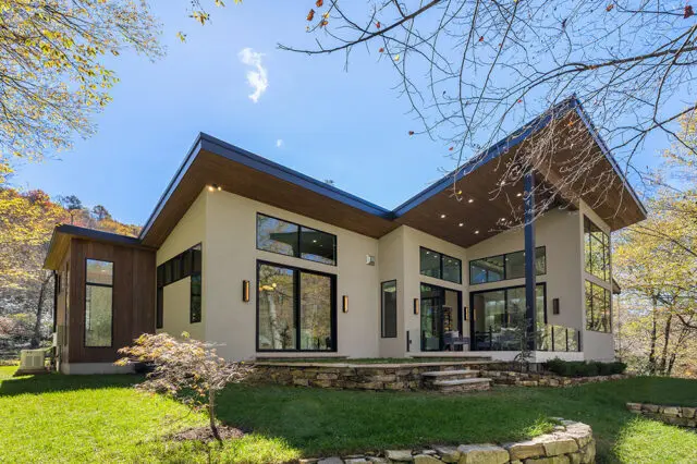 Modern house with beige siding, wood accents, and large windows.