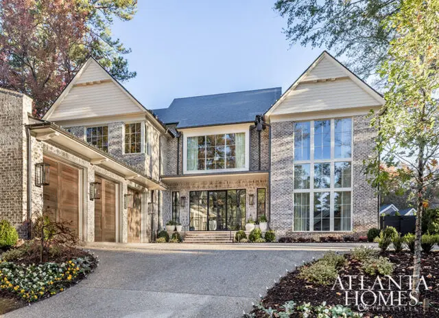 Modern brick home with large windows and a three-car garage.