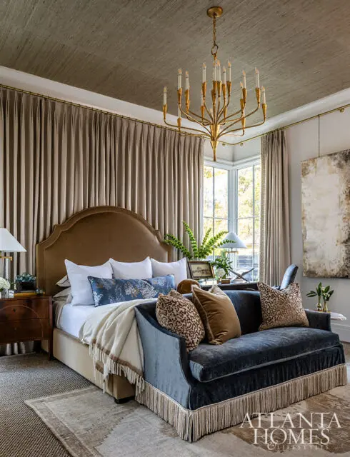 Bedroom with upholstered headboard, dark blue velvet sofa with fringe, and textured ceiling.