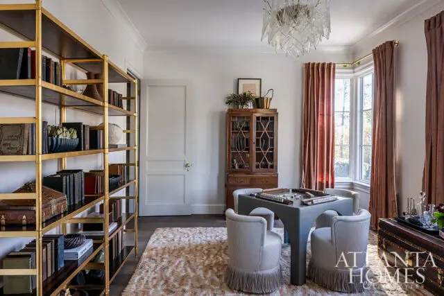 Study with gold bookshelf, game table, and velvet drapes